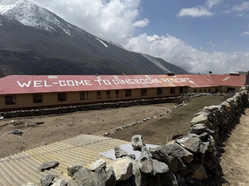 Building with 'Welcome to Dingboche Resort' painted on roof