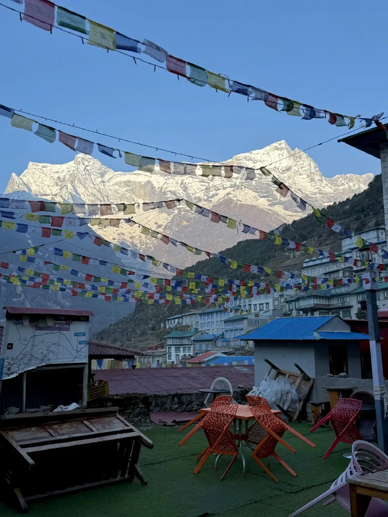 Café patio with prayer flags and Kongde Ri peaks with alpenglow