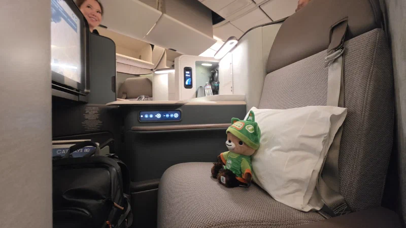 Sumi sitting in a Cathay Pacific business class seat