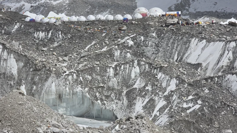 Wide view of Everest Base Camp with dozens of expedition tents along the glacier