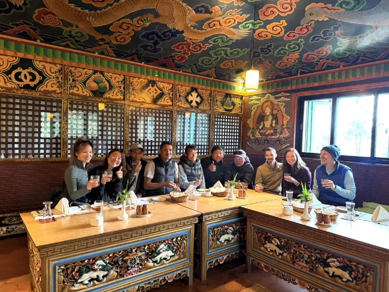 The full crew of eleven raising glasses at the farewell dinner under a golden dragon ceiling
