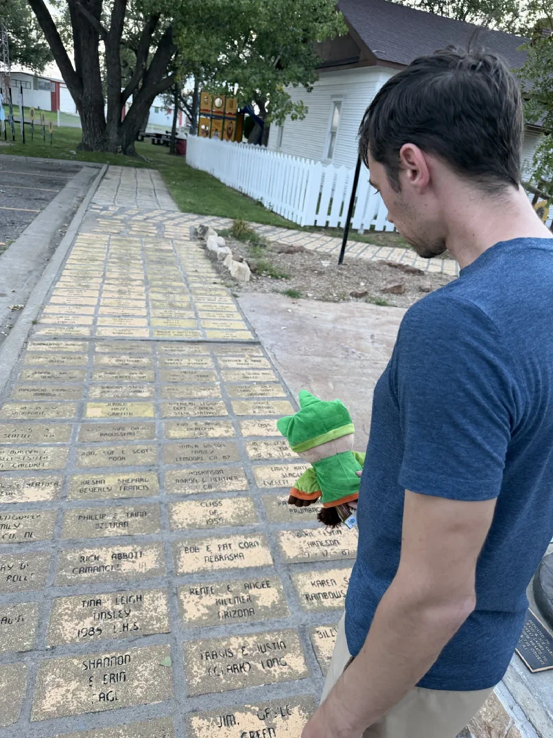 Nicholas looking down at a path of yellow bricks engraved with donor names and hometowns