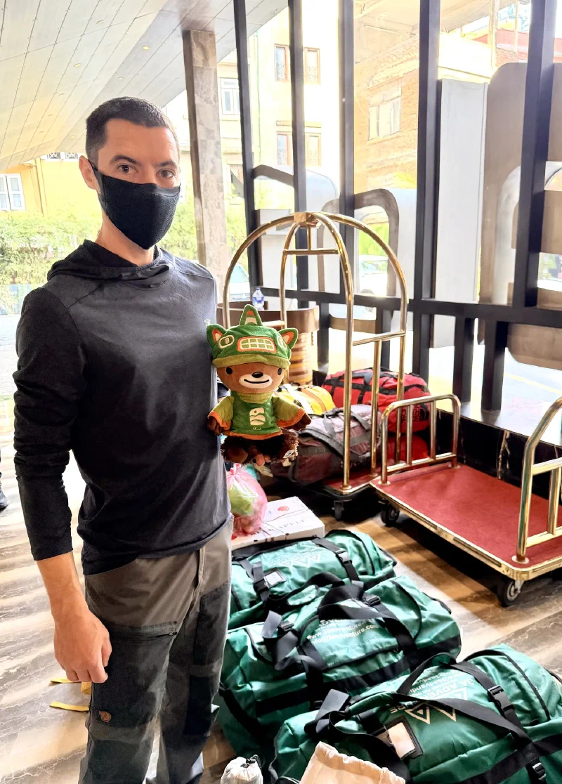 Nicholas holding Sumi in the Aloft hotel lobby surrounded by duffel bags