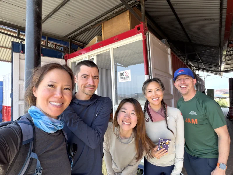 Group photo outside near the helipad: Pokin, Nicholas, Alice, Po On, and Steve
