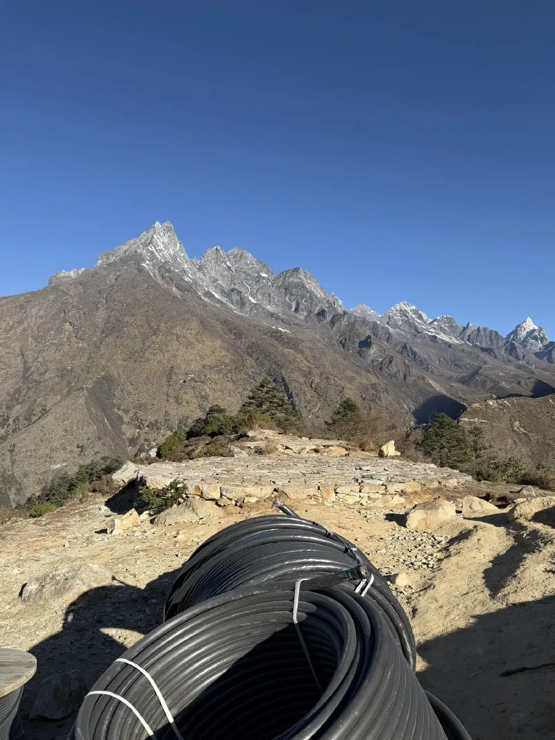 Mountain landscape from the helicopter landing area with coiled piping in the foreground