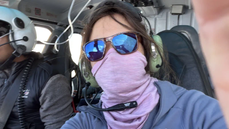 Pokin and Po On inside a helicopter wearing aviation headsets