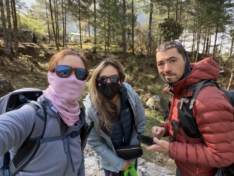 Three trekkers standing on a forest path looking slightly lost after being dropped at the wrong helicopter pad