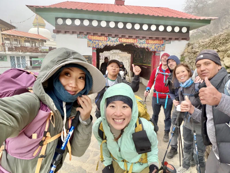 Group selfie at the Namche entrance gate with fog behind