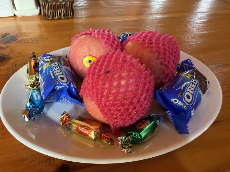 Farewell treat plate with apples in foam nets, Oreos, and wrapped candy