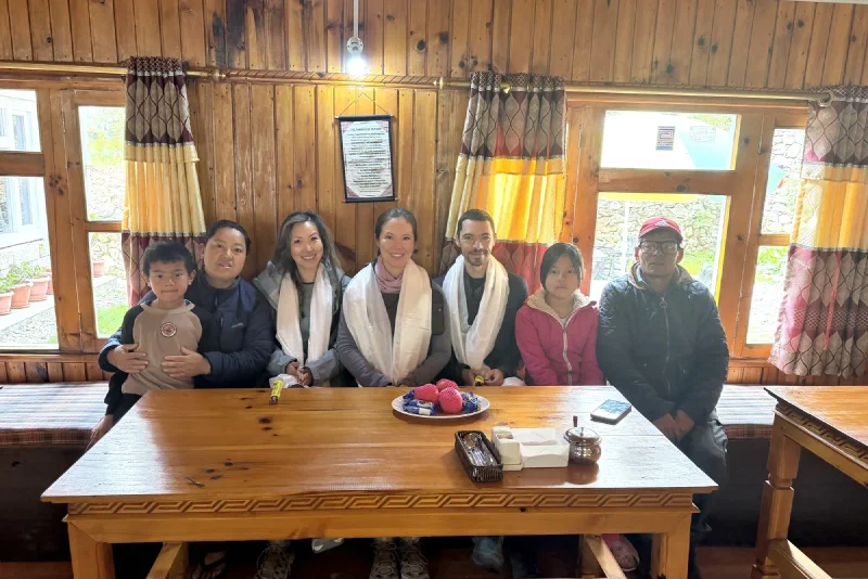 The Gurkha Inn family draping white khata scarves on the trekkers in the dining room