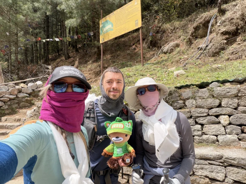 Nicholas, Pokin, and Po On posing at the trailhead, Sumi held in front