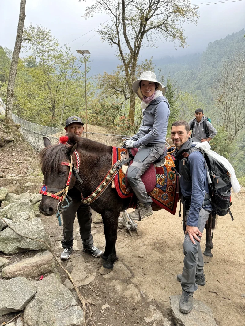 Pokin and the group nearing Lukla, forested hills behind
