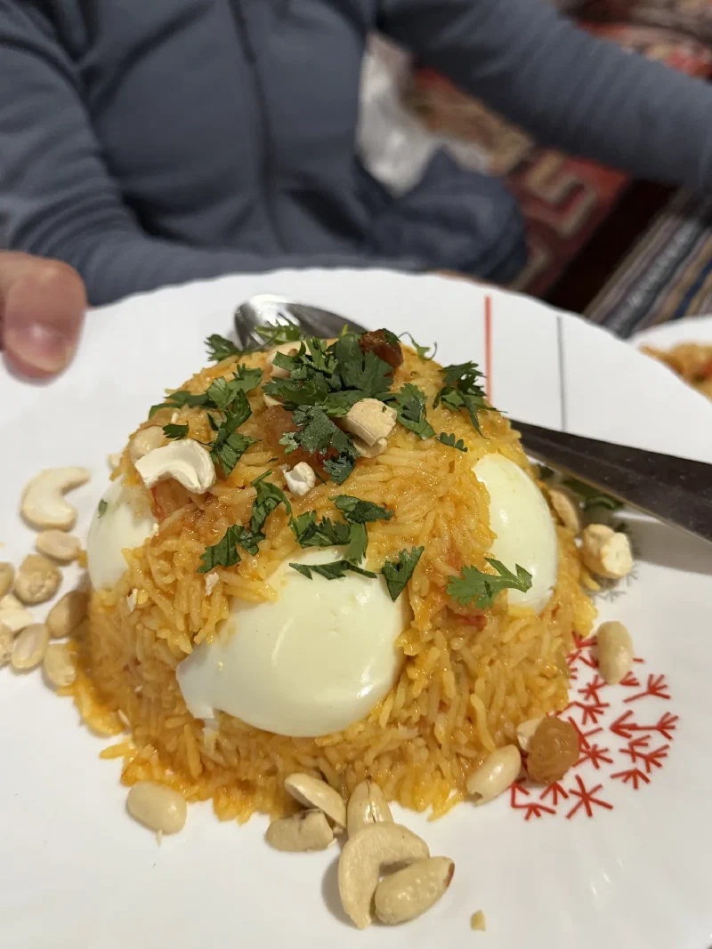 A plated rice dish with hard-boiled eggs, cashews, and herbs at the Yak Hotel