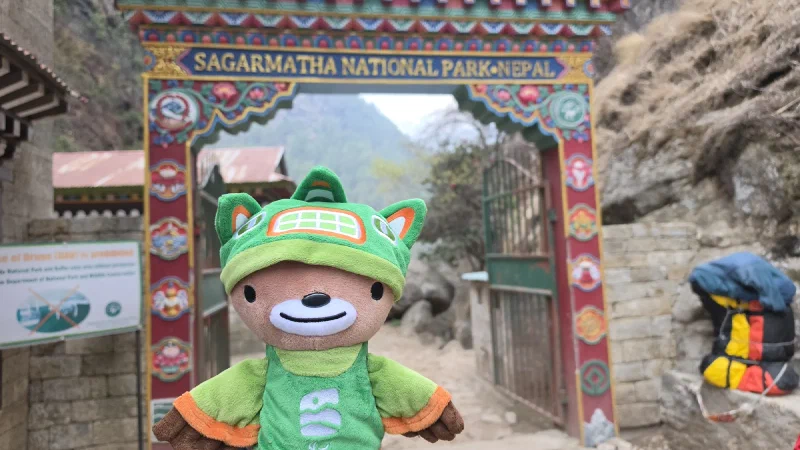 Sumi held up in front of the ornate Sagarmatha National Park entrance gate