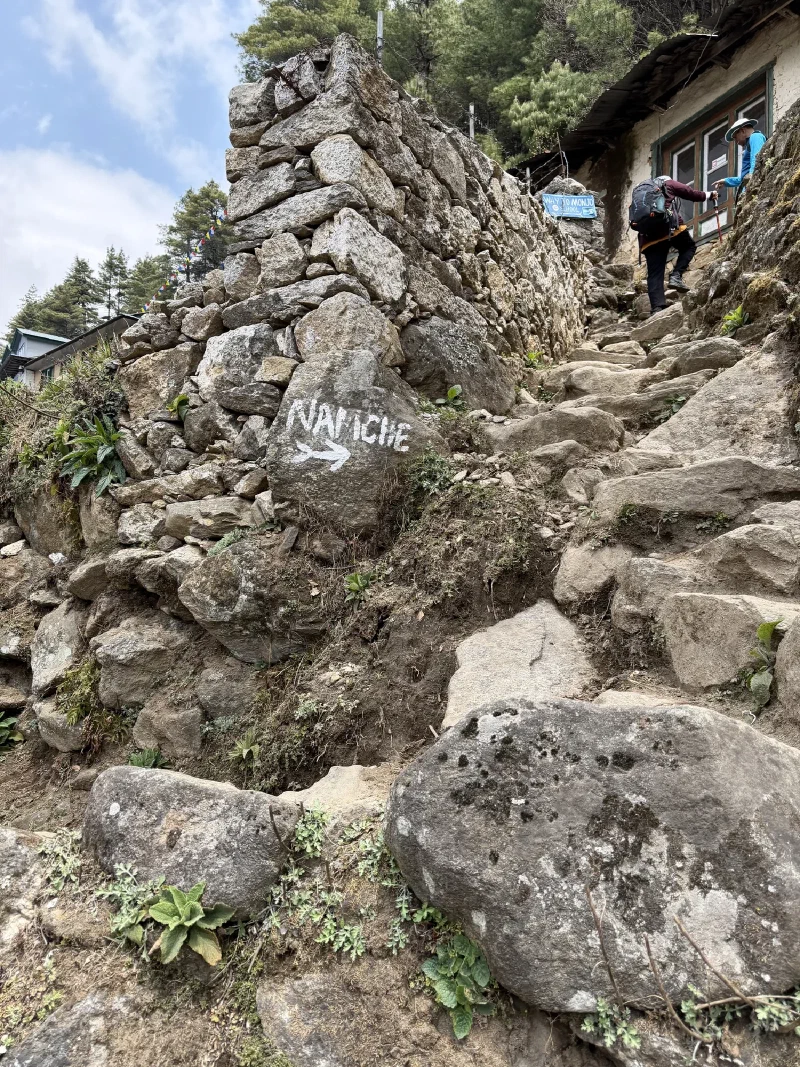 Steep stone staircase on the trail with NAMCHE painted on a boulder