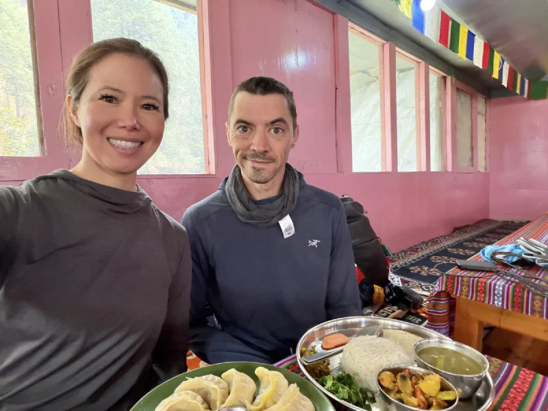 Pokin and Nicholas selfie with momos and dal bhat on the table