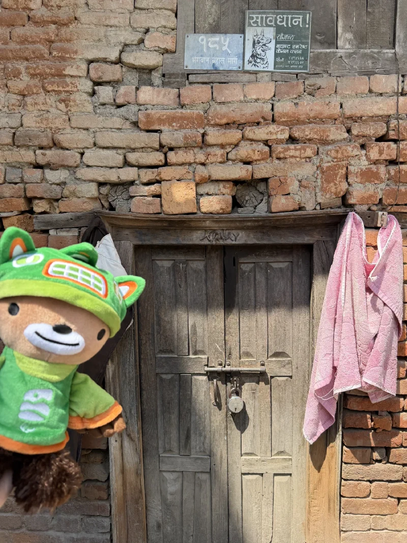 Sumi in front of a rustic wooden door in Kathmandu