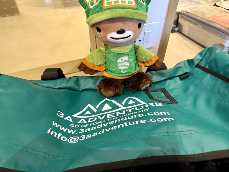 Sumi sitting on top of an empty 3A Adventure duffel bag