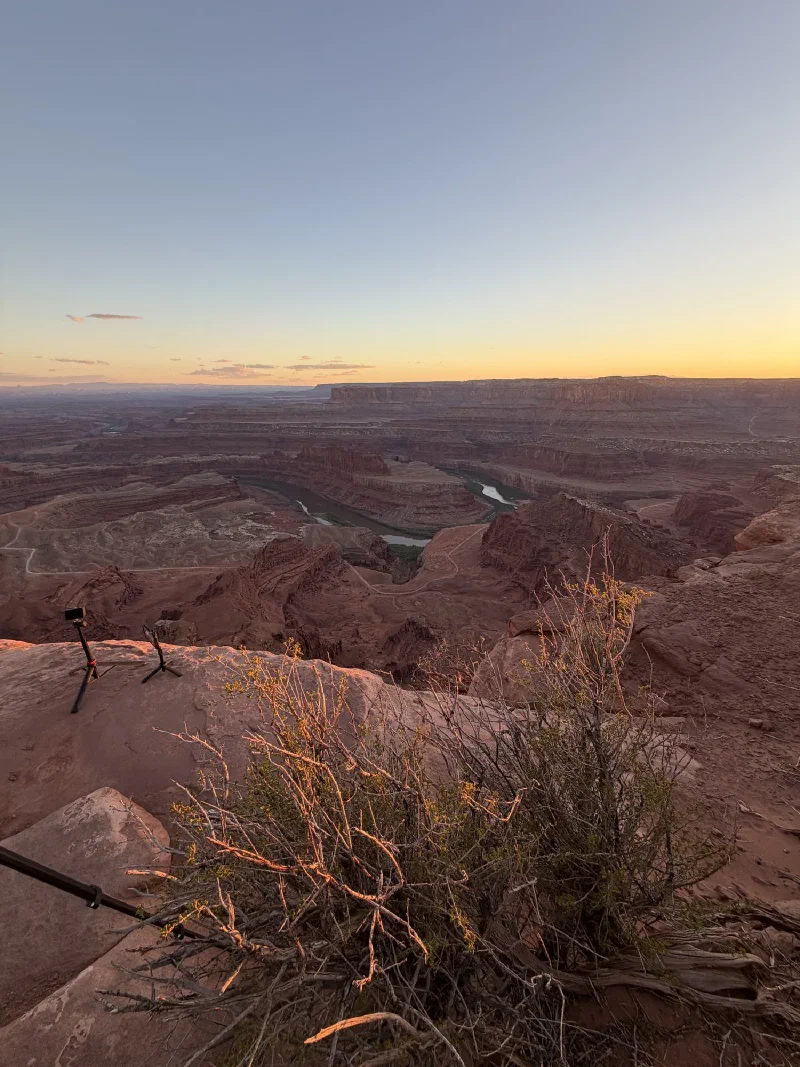 Two phones on small tripods set up on the slickrock facing the canyon at sunset