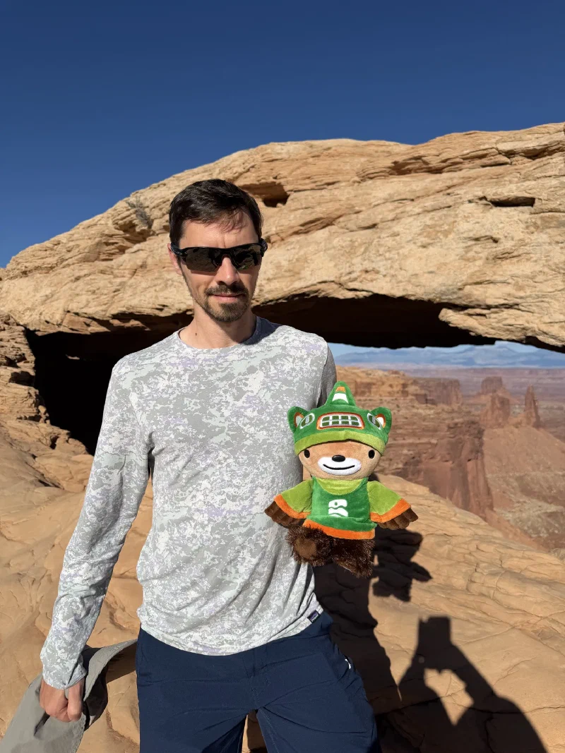 Nicholas holding Sumi in front of Mesa Arch