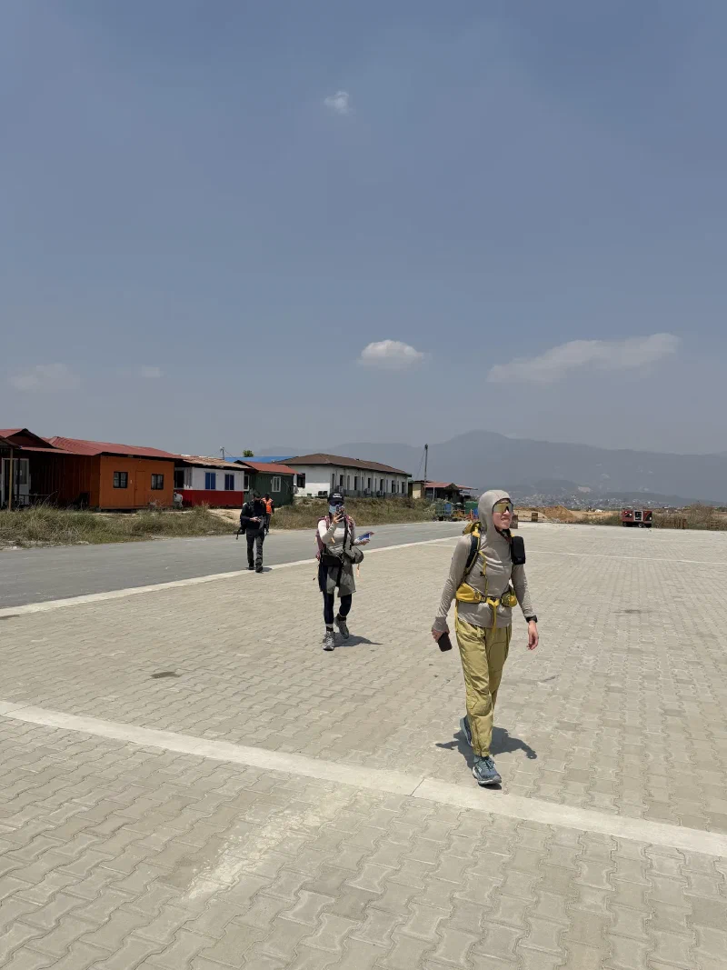 Alice, Po On, and Nicholas walking across the Kathmandu airfield