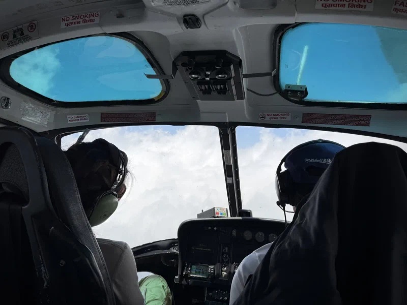 View through the helicopter cockpit showing thick clouds ahead