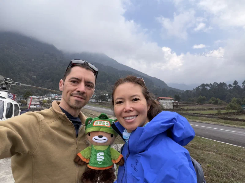 Nicholas, Pokin, and Sumi selfie at Lukla with a helicopter behind them