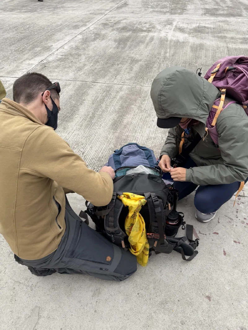 Nicholas and Po On sorting gear on the ground at Lukla