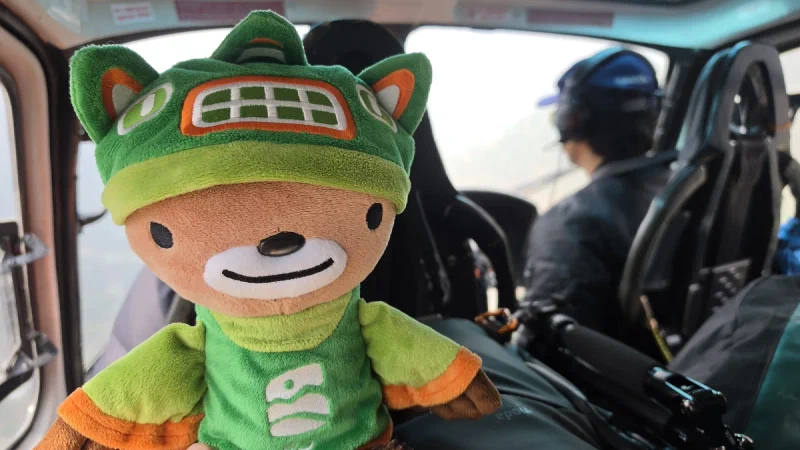 Sumi inside the helicopter with the pilot visible behind