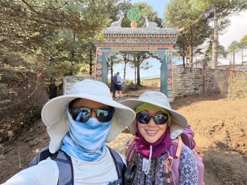 Pokin and Po On selfie at Sagarmatha National Park gate with decorative Buddhist motifs