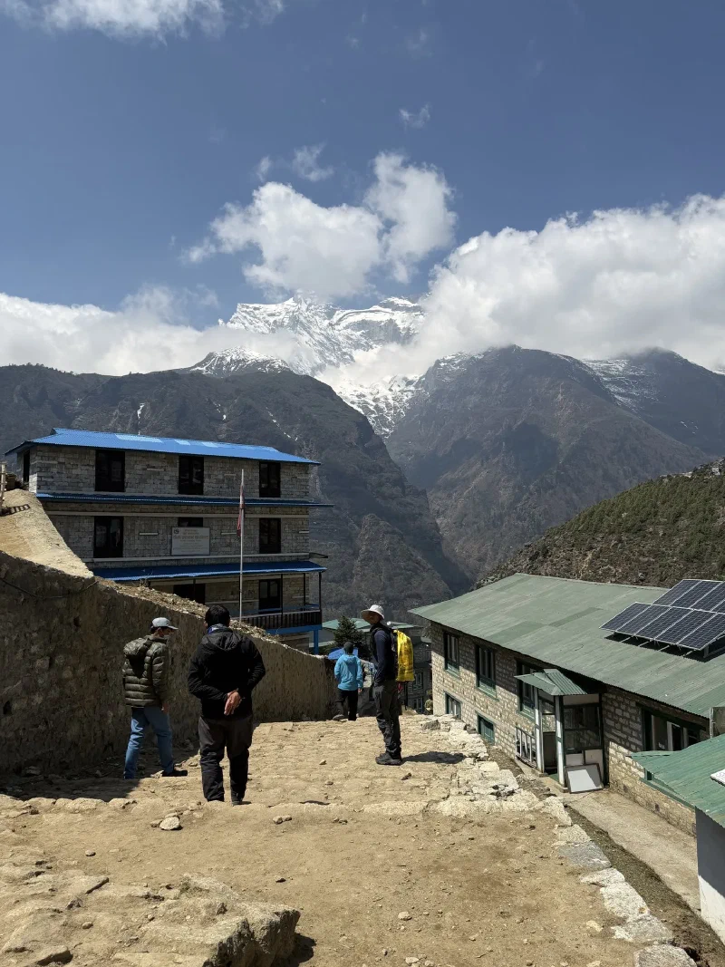 Walking down to the hospital complex with solar panels and snow peak in background