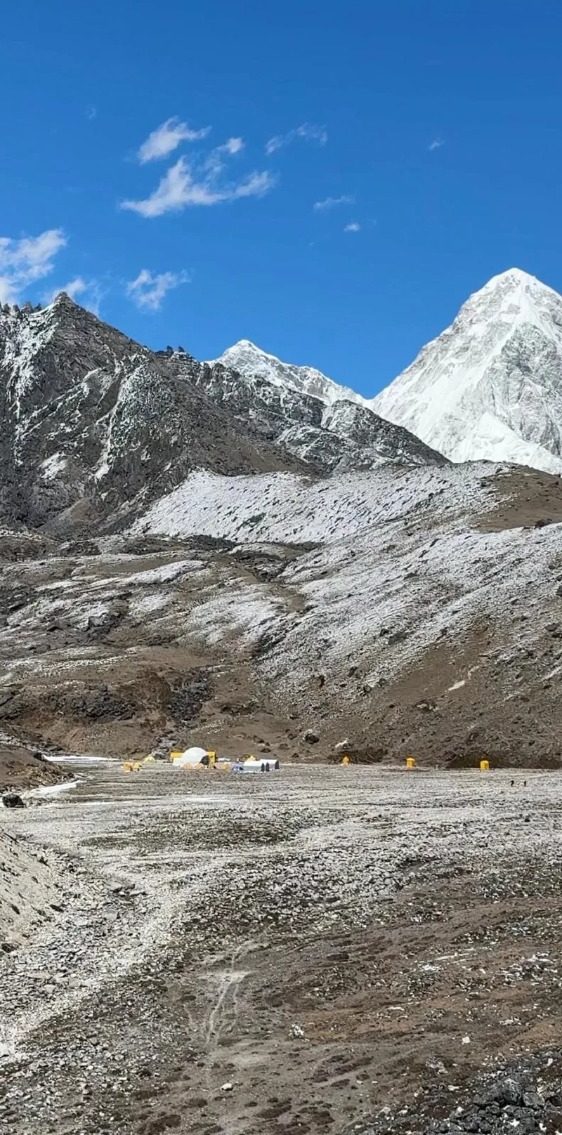 Lobuche base camp with dome tents in a rocky valley below snow-covered peaks