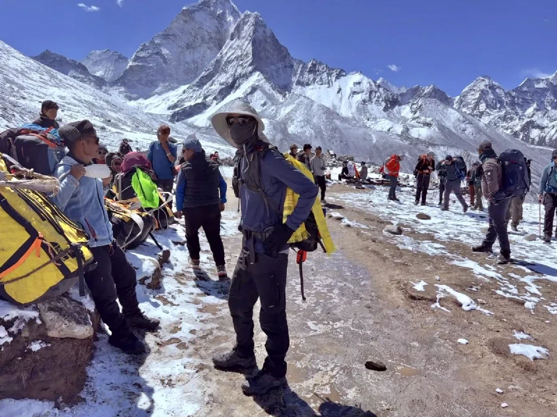 Nicholas standing among trekkers with Ama Dablam behind
