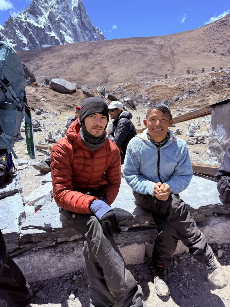 Nicholas and Kerman sitting on a stone wall near the memorial
