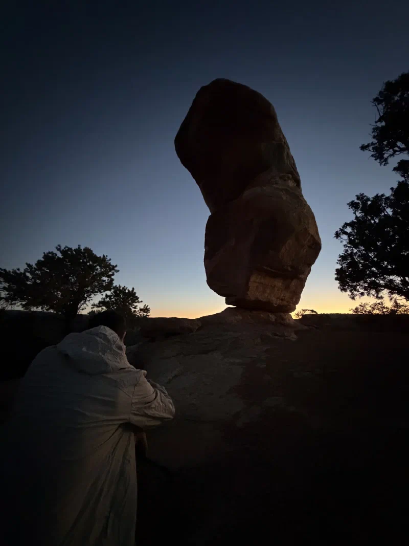 Miracle Rock silhouetted black against deep blue twilight with the last orange light on the horizon