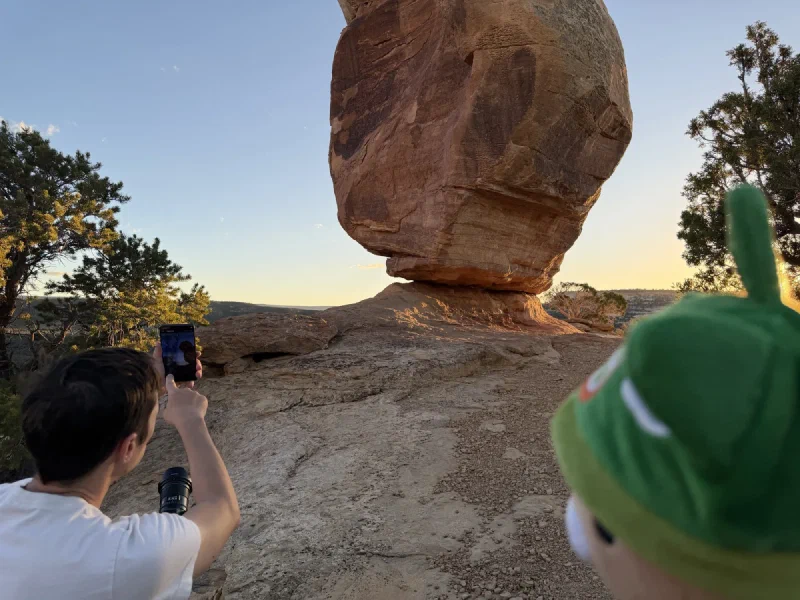 Nicholas photographing Miracle Rock in golden light, Sumi’s green toque huge in the foreground
