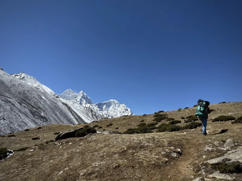 Nilman on the trail with shrubs and mountains