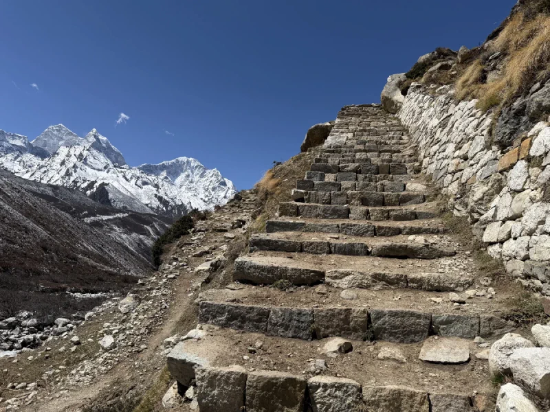 Steep stone staircase on the trail with mountains in distance