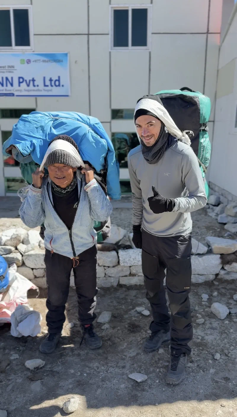 Nicholas and a porter with namlo bags, Nicholas giving a thumbs up