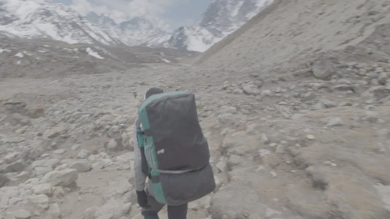 Nicholas from behind hiking with the porter load