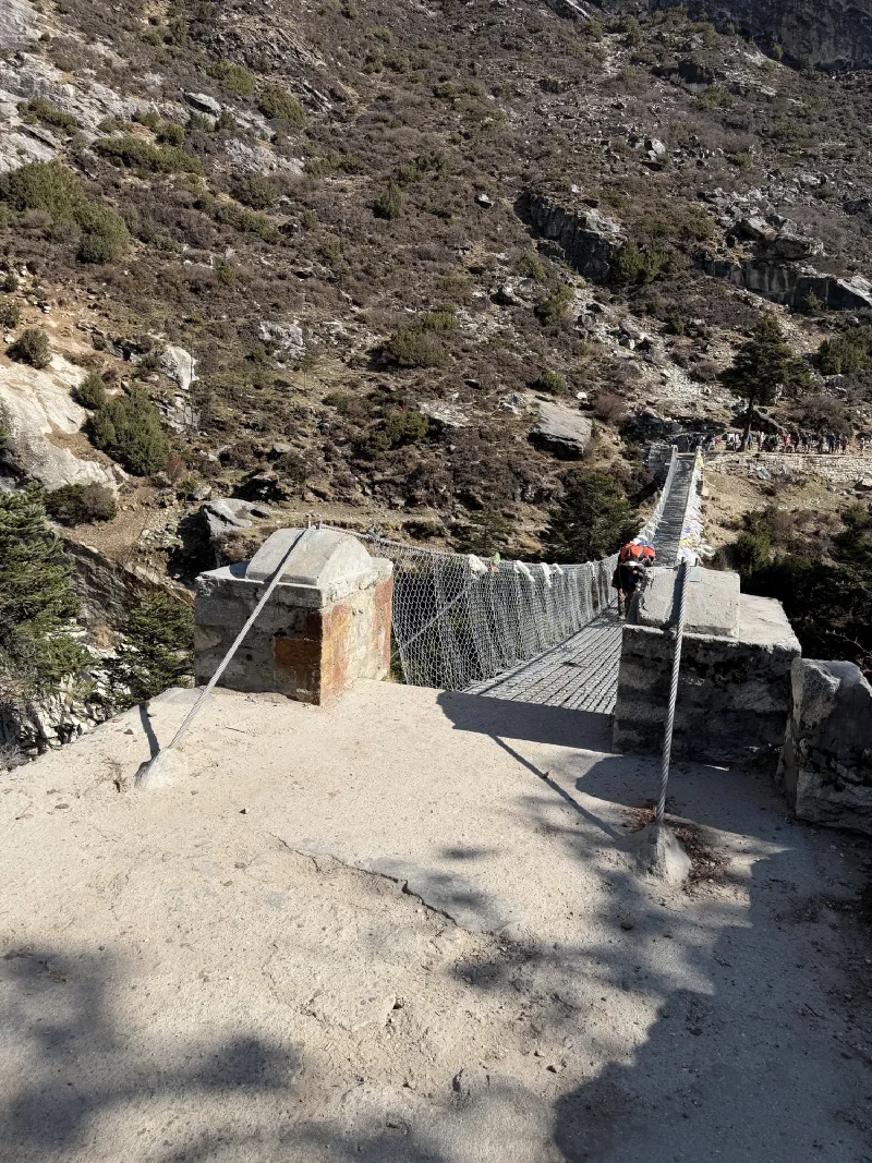 Suspension bridge over gorge with prayer flags