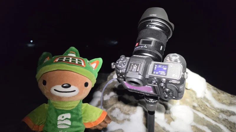Camera on tripod aimed at dark sky with Sumi in foreground