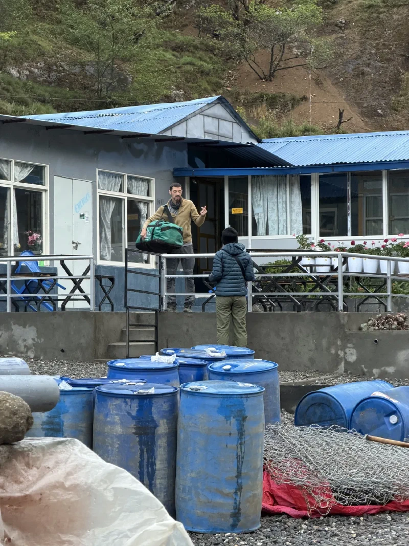 Nicholas carrying a bag out of the lodge to wait outside