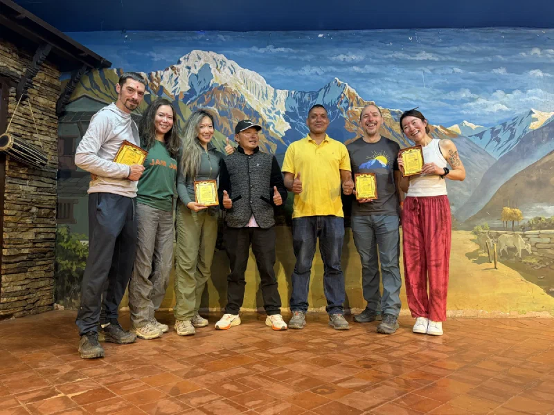 The whole group lined up on stage holding their framed trek completion plaques