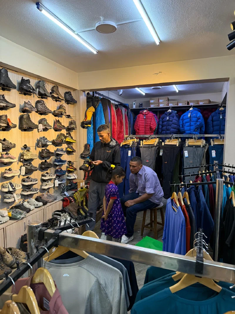 Manoj and his young daughter sitting in a sporting goods store
