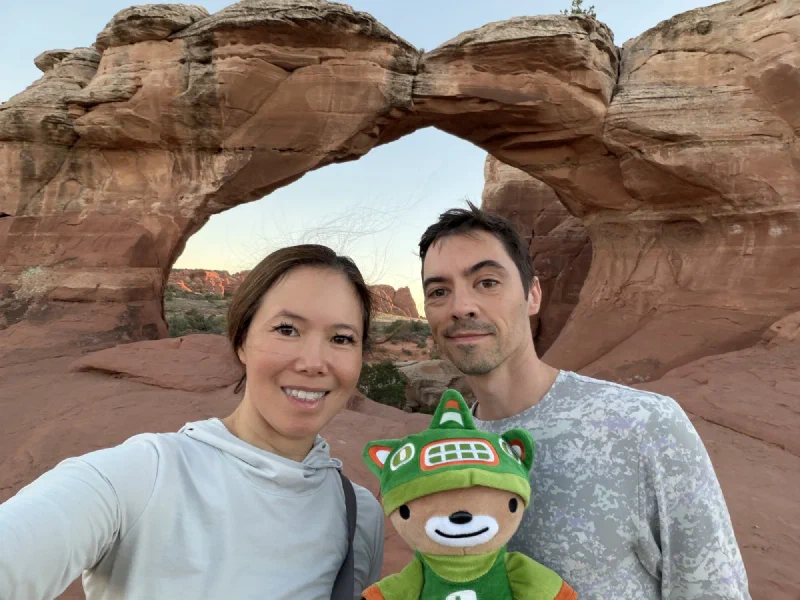 Pokin and Nicholas with Sumi between them, Broken Arch framing the sky behind at sunset