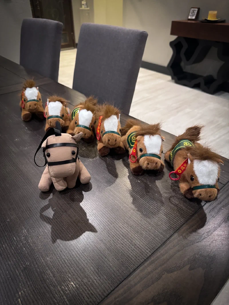 Chestnut the stuffed horse surrounded by a herd of horse figurines on the dining table